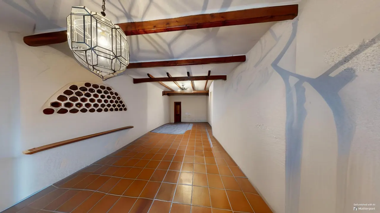 Bodega con vigas de madera, botellero y lámpara de forja