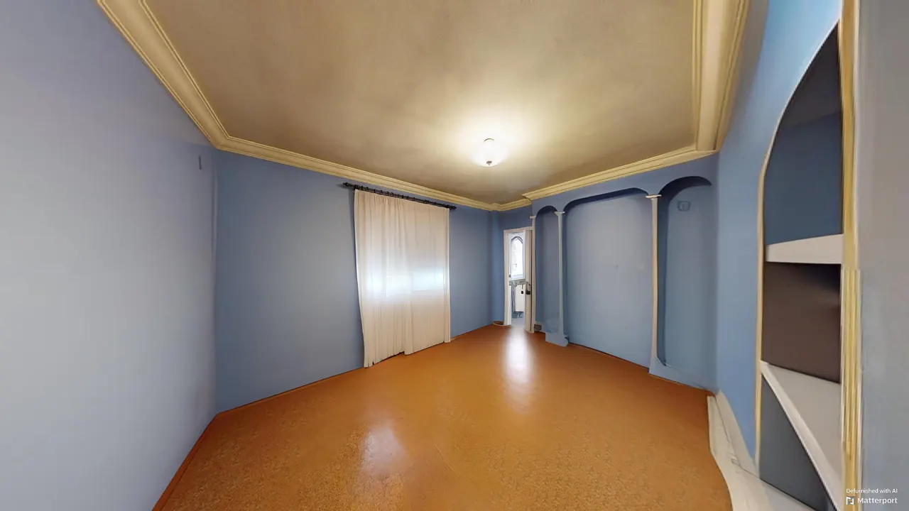 Dormitorio 2 con paredes en tono azul y techo con moldura