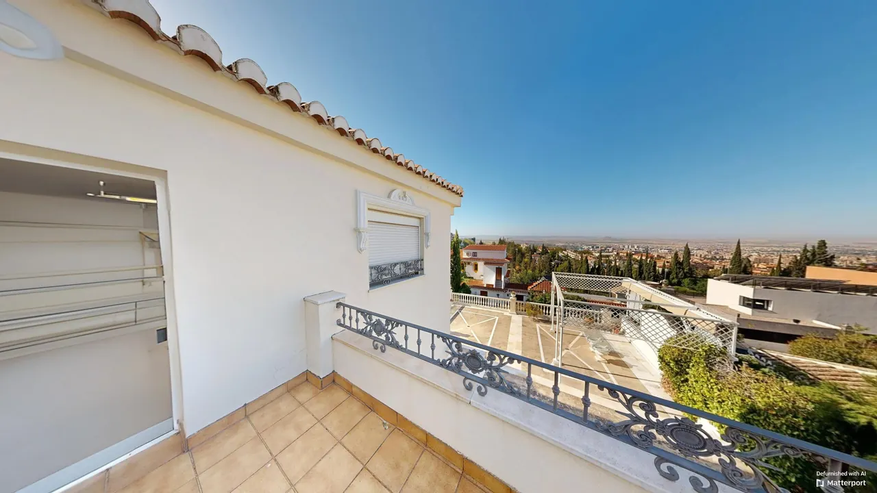 Terraza de la planta primera con barandilla de forja y vistas panorámicas